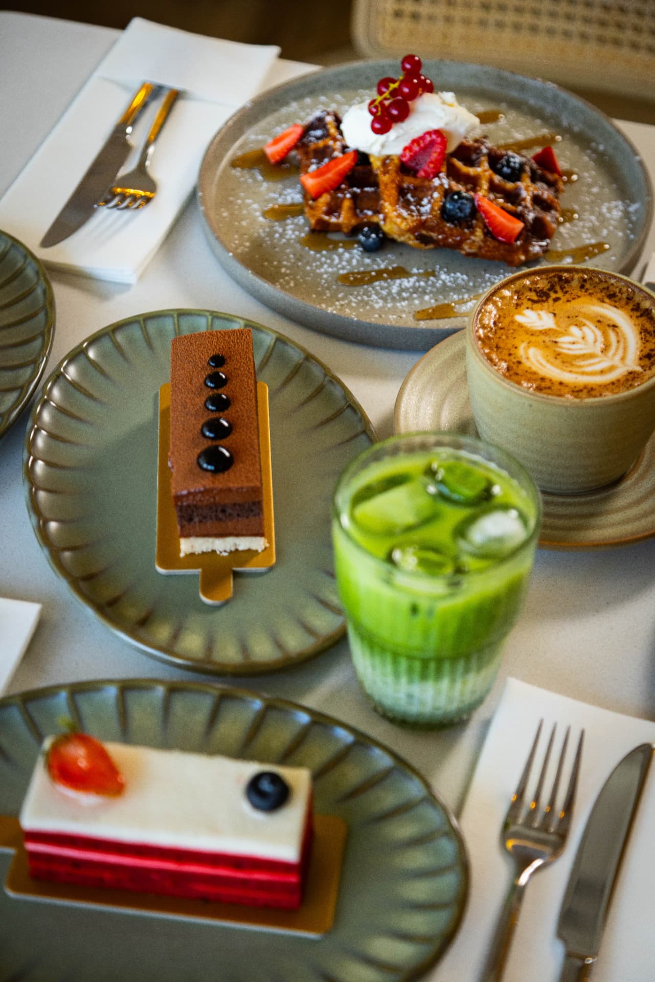 Chocolate and red velvet cake slices with iced matcha and cappuccino at Tavia Cafe & Restaurant DSO