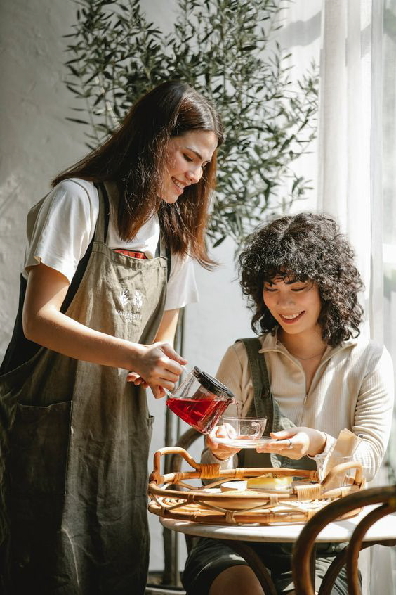 Tavia kitchen — server pouring tea for a guest